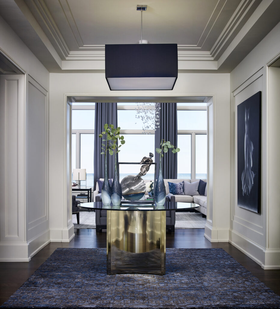 Glass table with metal statue in hallway leading to living room