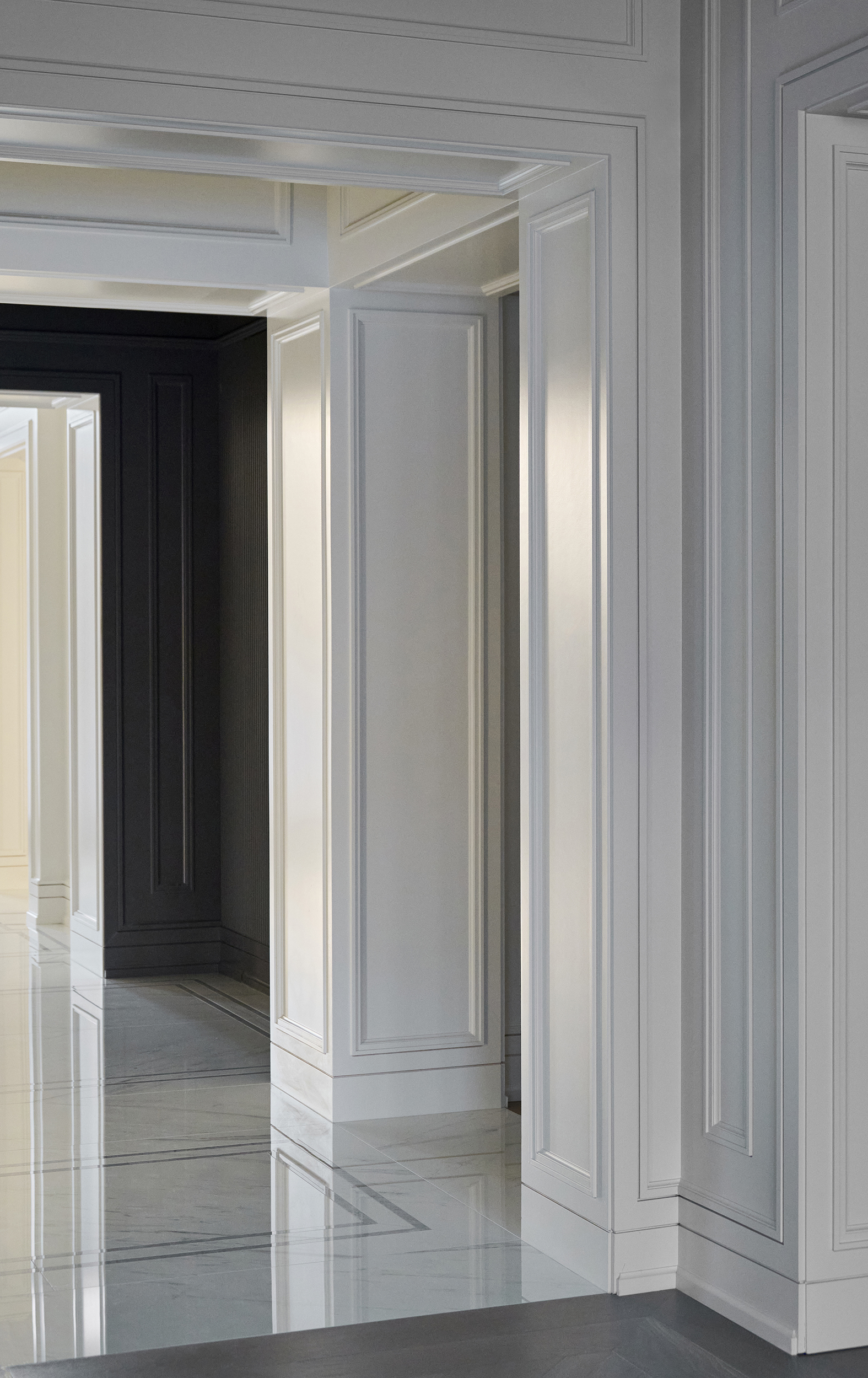 Hallway with white walls and marble floor tiles