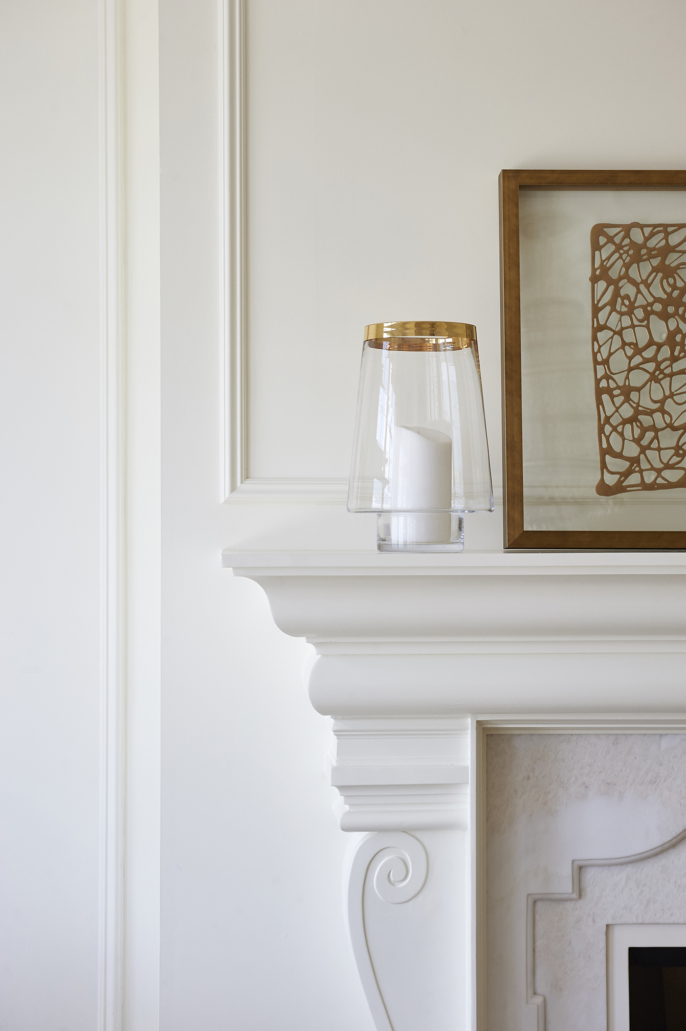A lamp with gold rims atop a fireplace