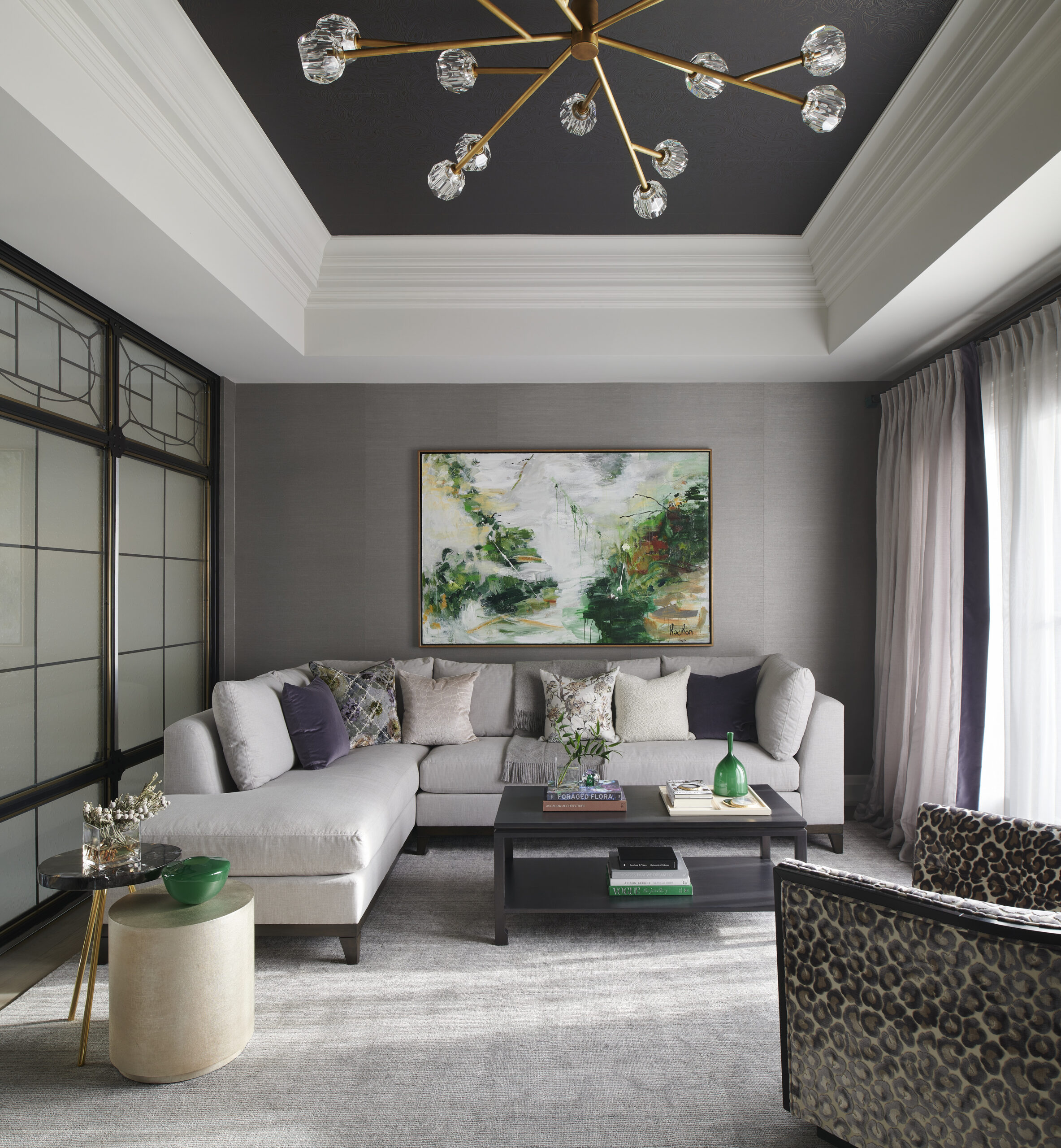 Chateau on the Lake - A quiet sitting room with a big grey couch and a large nature painting